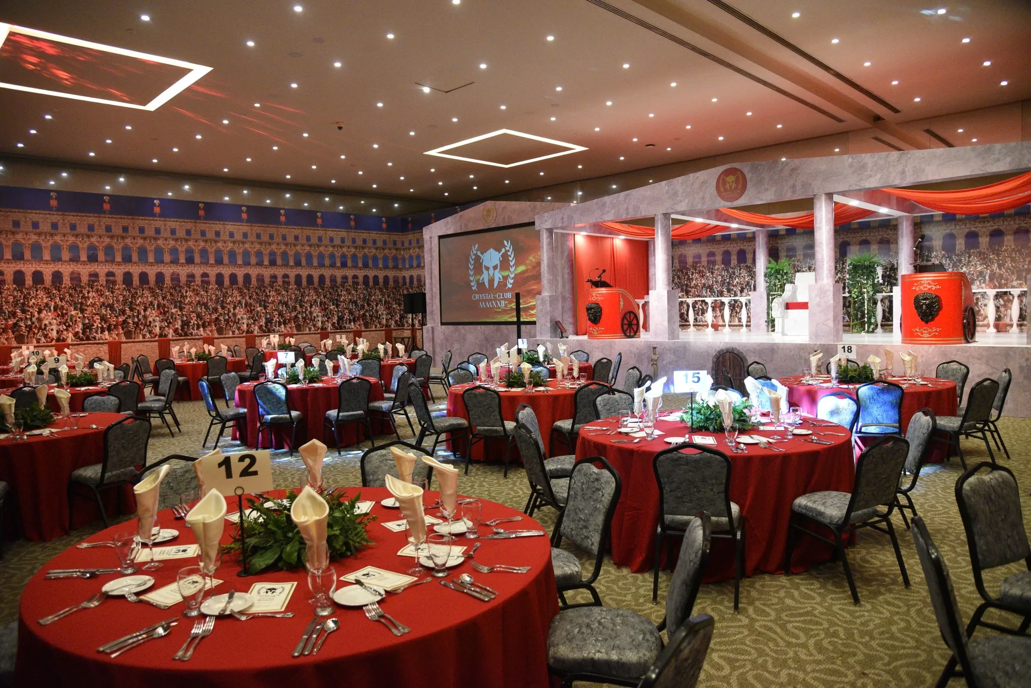 Corporate event with red banquet tables and stage