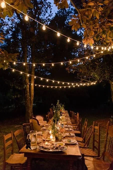 Outdoor dinner beneath string lights